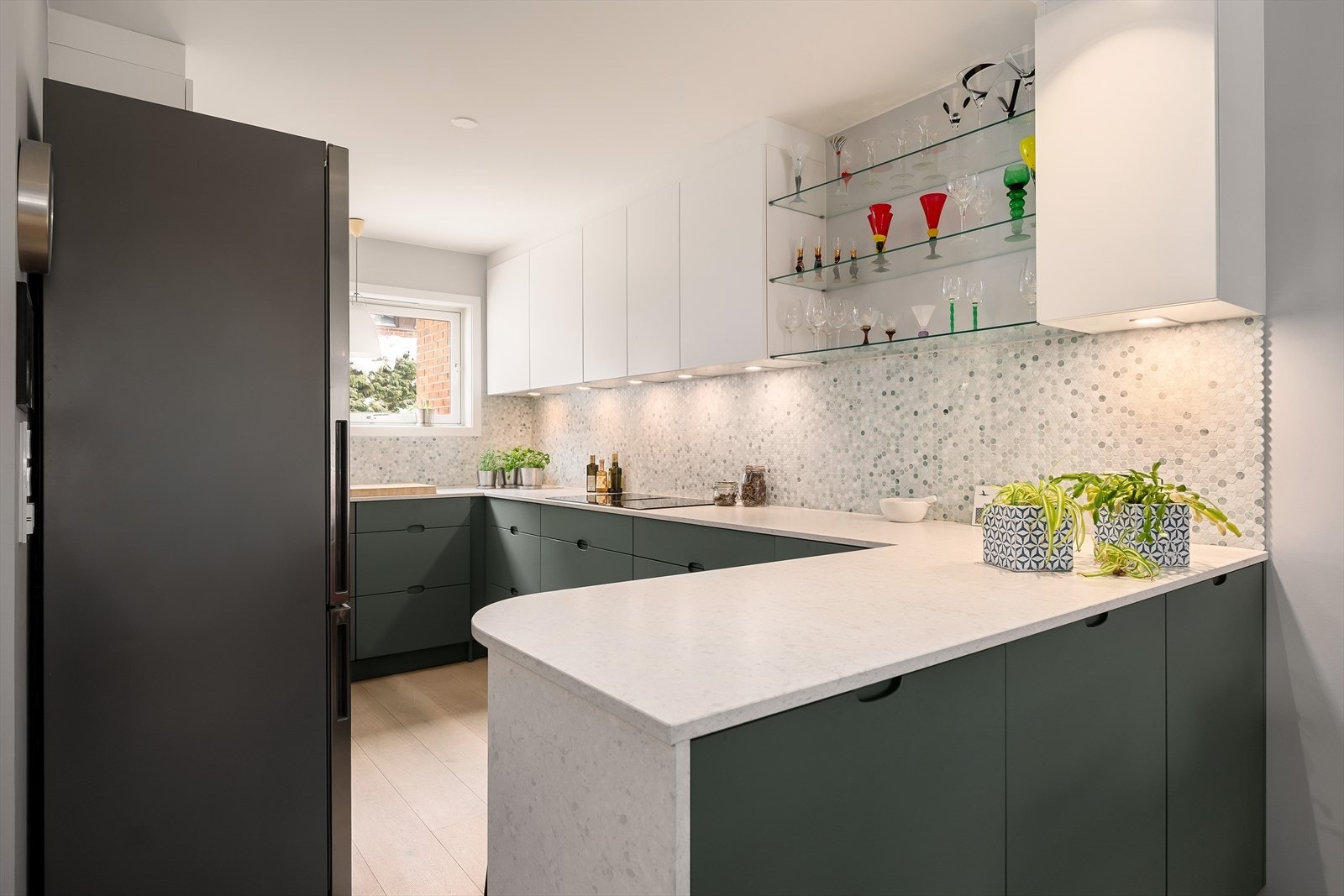 Innredningen består av delvis integrerte hvitevarer, benkeplate av kompsittsten, vinskap m.m Galleribilde