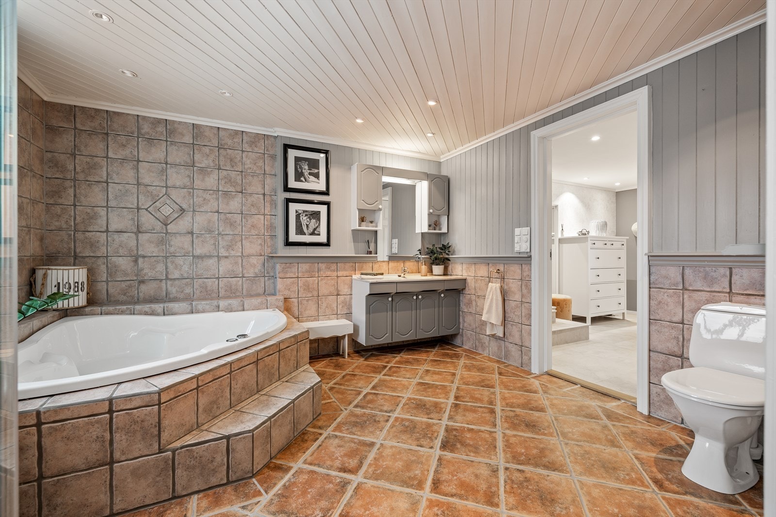 Badet har fliser på gulv og vegger samt panel/tømmer Galleribilde