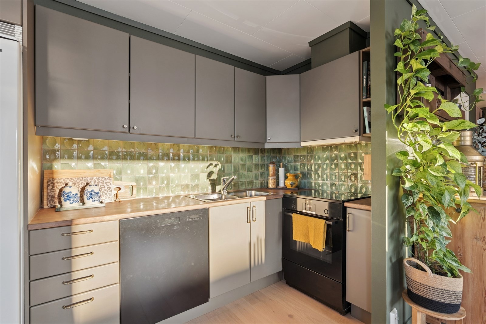 Kjøkkenet har slette fronter i malt utførelse og benkeplate av tre. Galleribilde