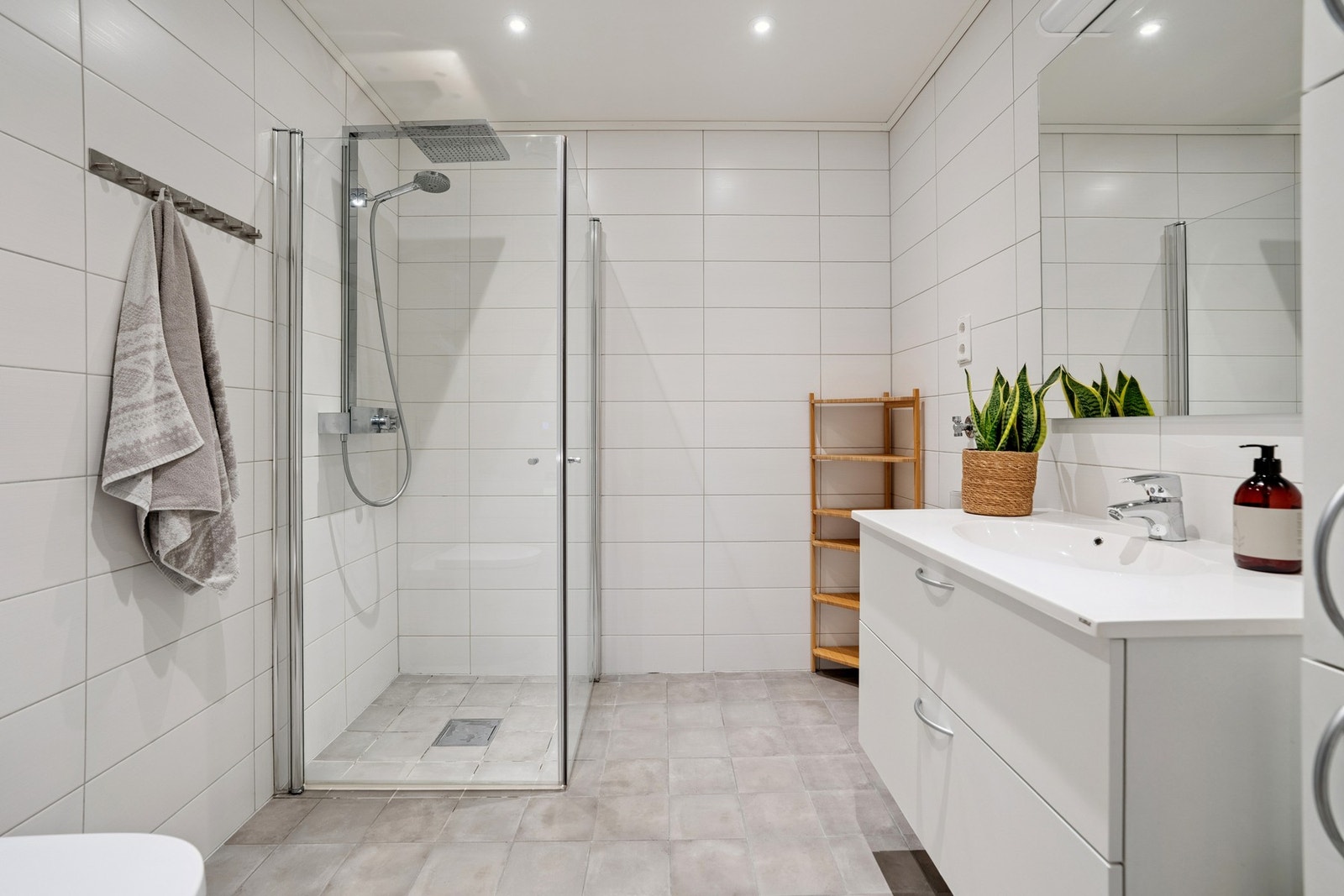 Bad med flislagte gulv og vegger. Det er opplegg for vaskemaskin, men også eget vaskerom Galleribilde