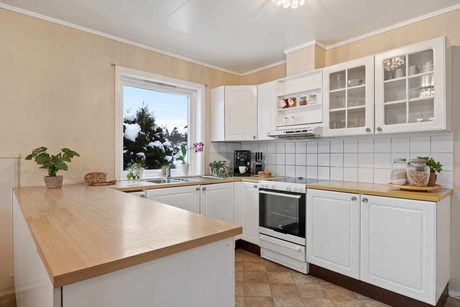 Kjøkkenet har en praktisk halvøy som gir ekstra benkeplass og en sosial sone. Galleribilde