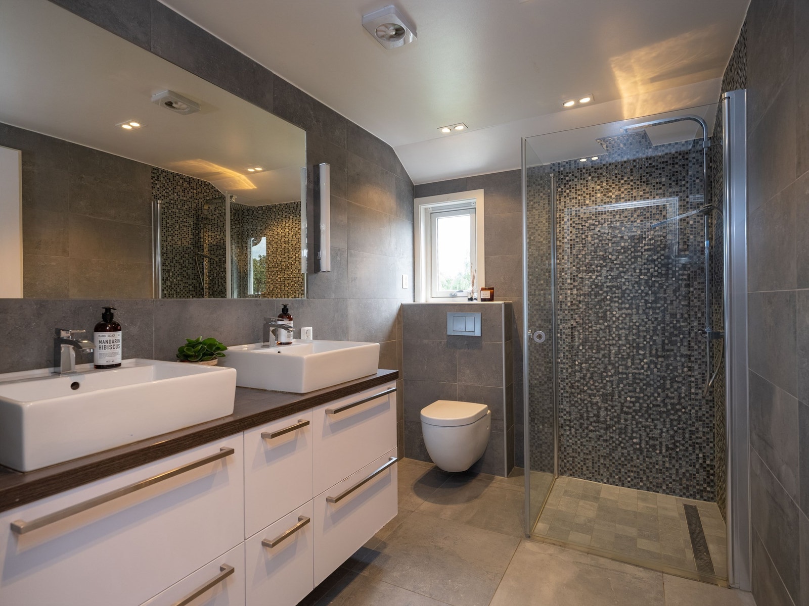 Meget pent flislagt bad i 2.etg. på 5,5 kvm med varme i gulv og downlights i himling. Galleribilde