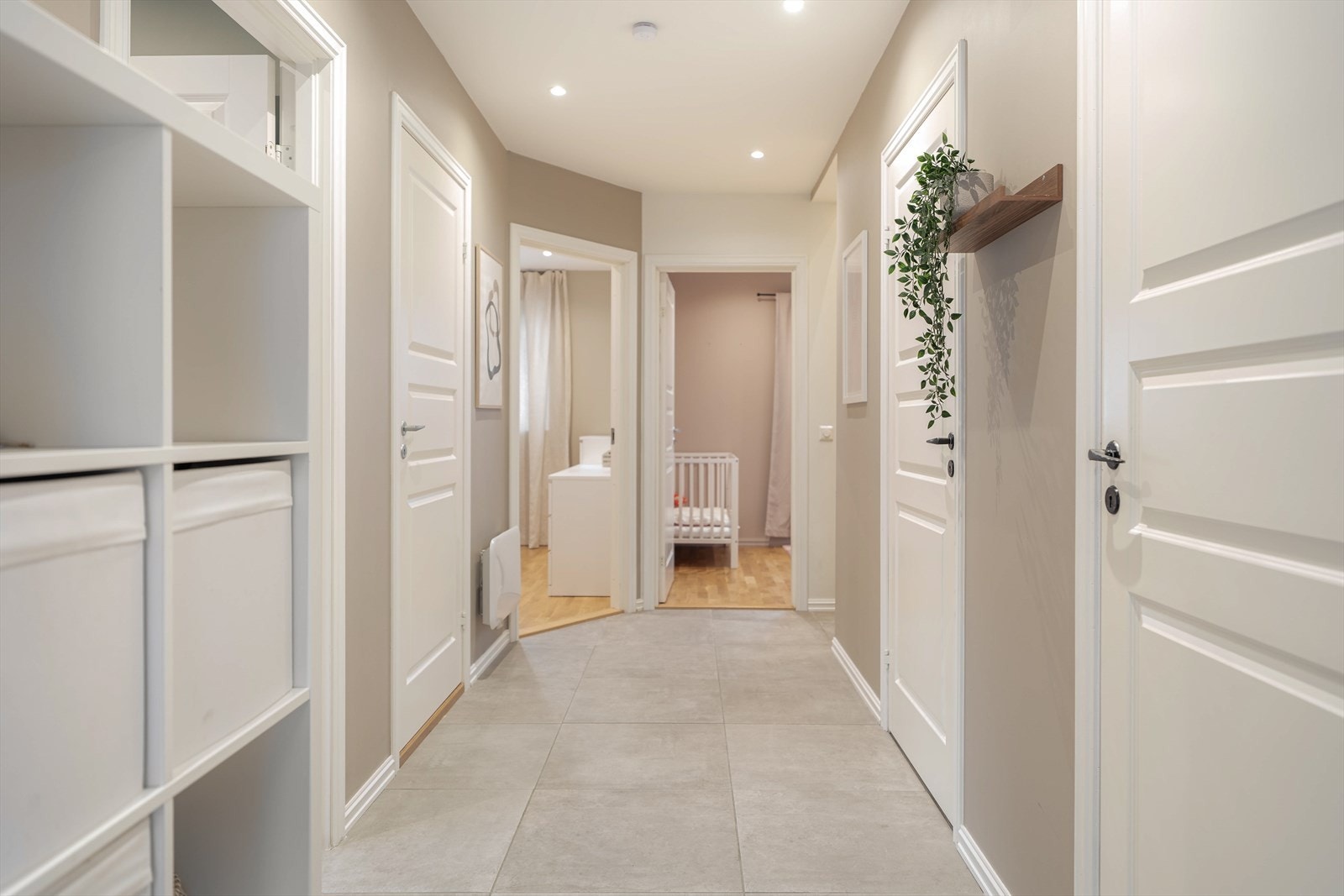 Lys og innbydende entré med moderne fliser og stilrent design. Her er det varmekabler i gulvet og ellers plass til oppheng av sko og jakker. Galleribilde