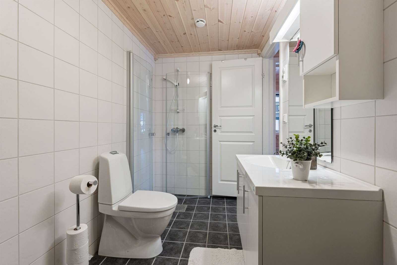 Badet er fra byggeåret 2014 og har helflisede vegger og trepanel i himlingen. Gulvet er flislagt og har to sluk, hvorav ett er plassert i dusjnisjen. Galleribilde