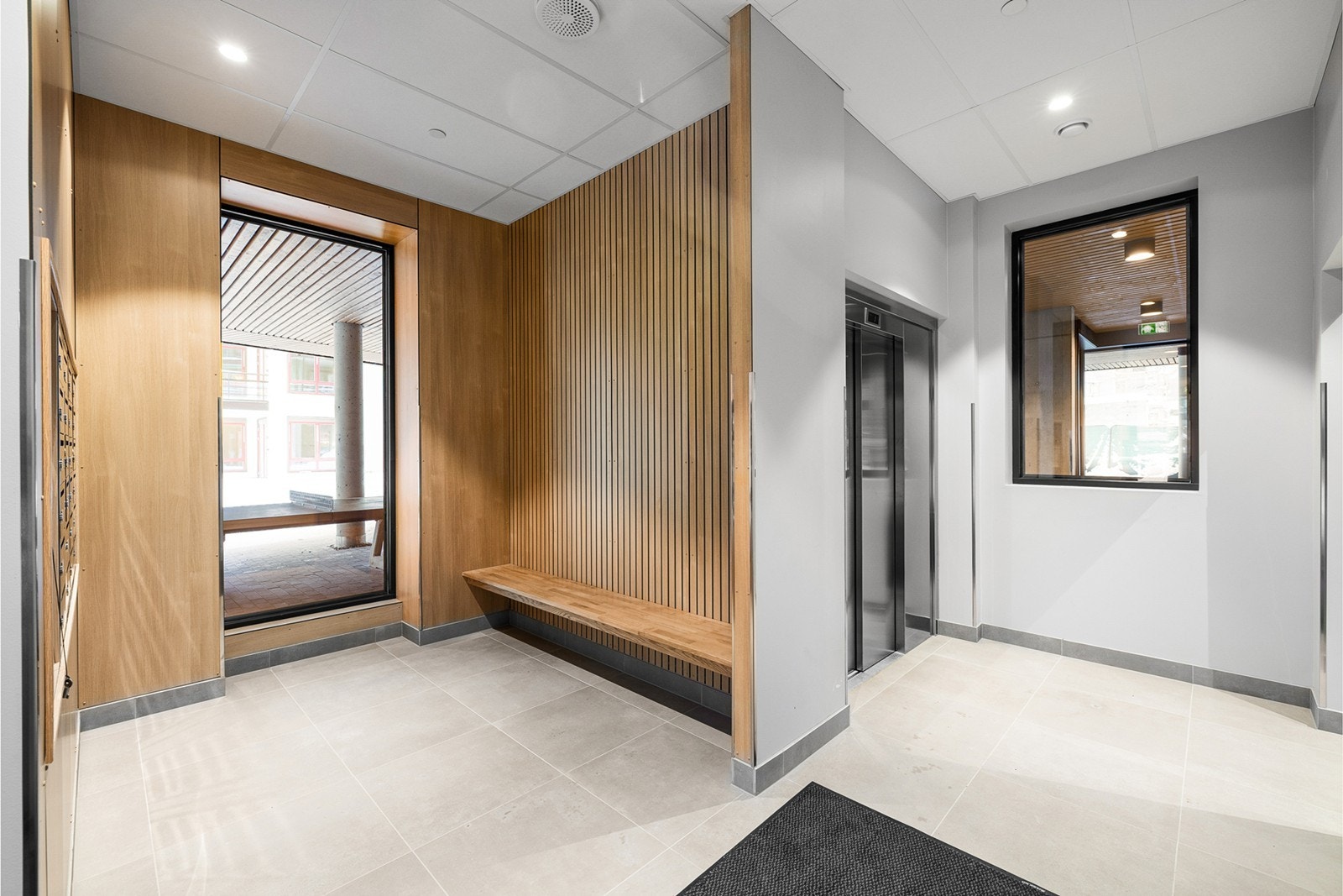 Pent og moderne felles inngangsparti med gjennomtenkte materialvalg og et stilrent uttrykk. Inngangspartiet fremstår lyst og romslig, med heisadkomst som gir et hyggelig førsteinntrykk for både beboere og gjester. Galleribilde