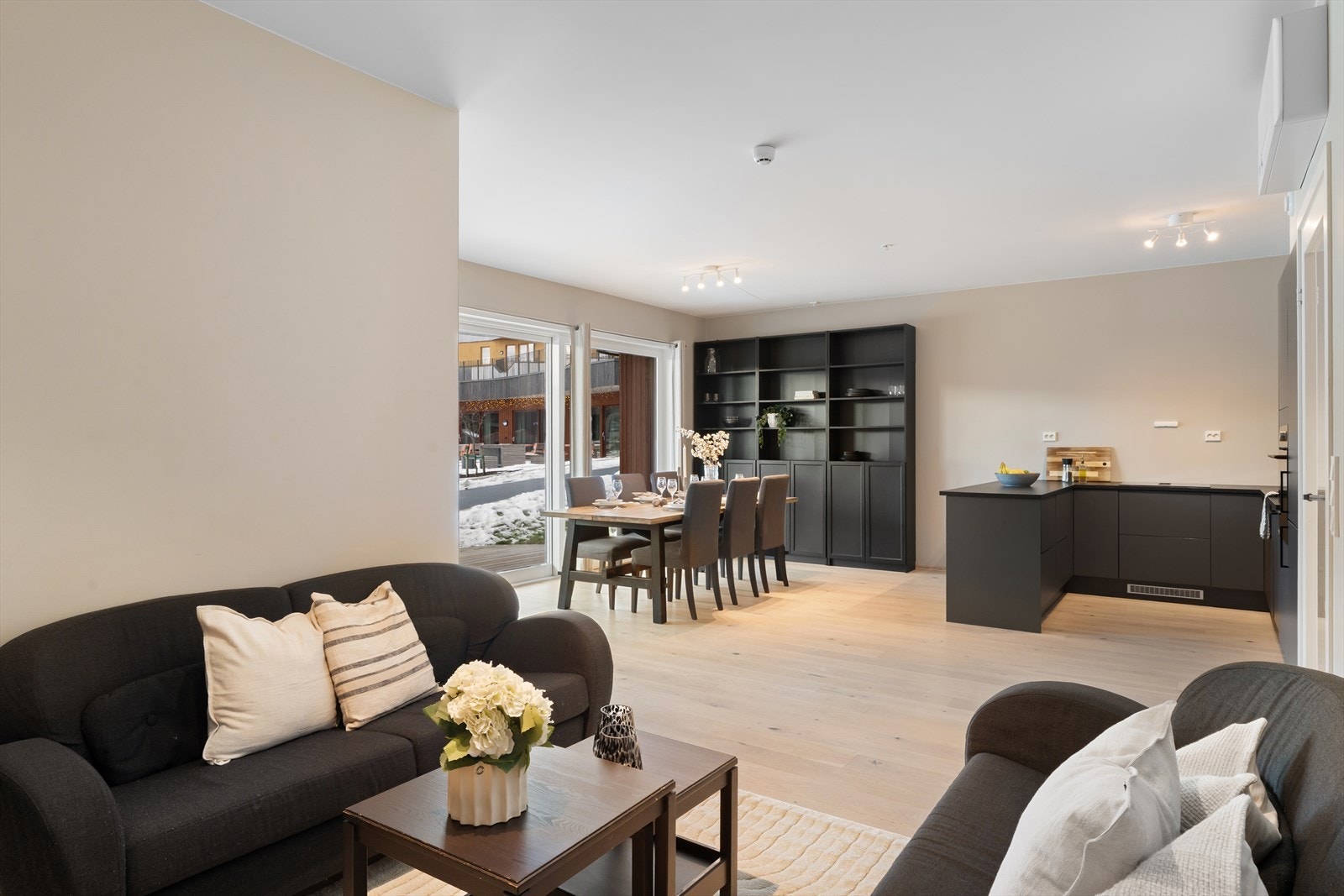 Selv med en åpen kjøkkenløsning gir planløsningen en tydelig oppdeling i soner, som skaper en balansert og harmonisk følelse i rommet Galleribilde