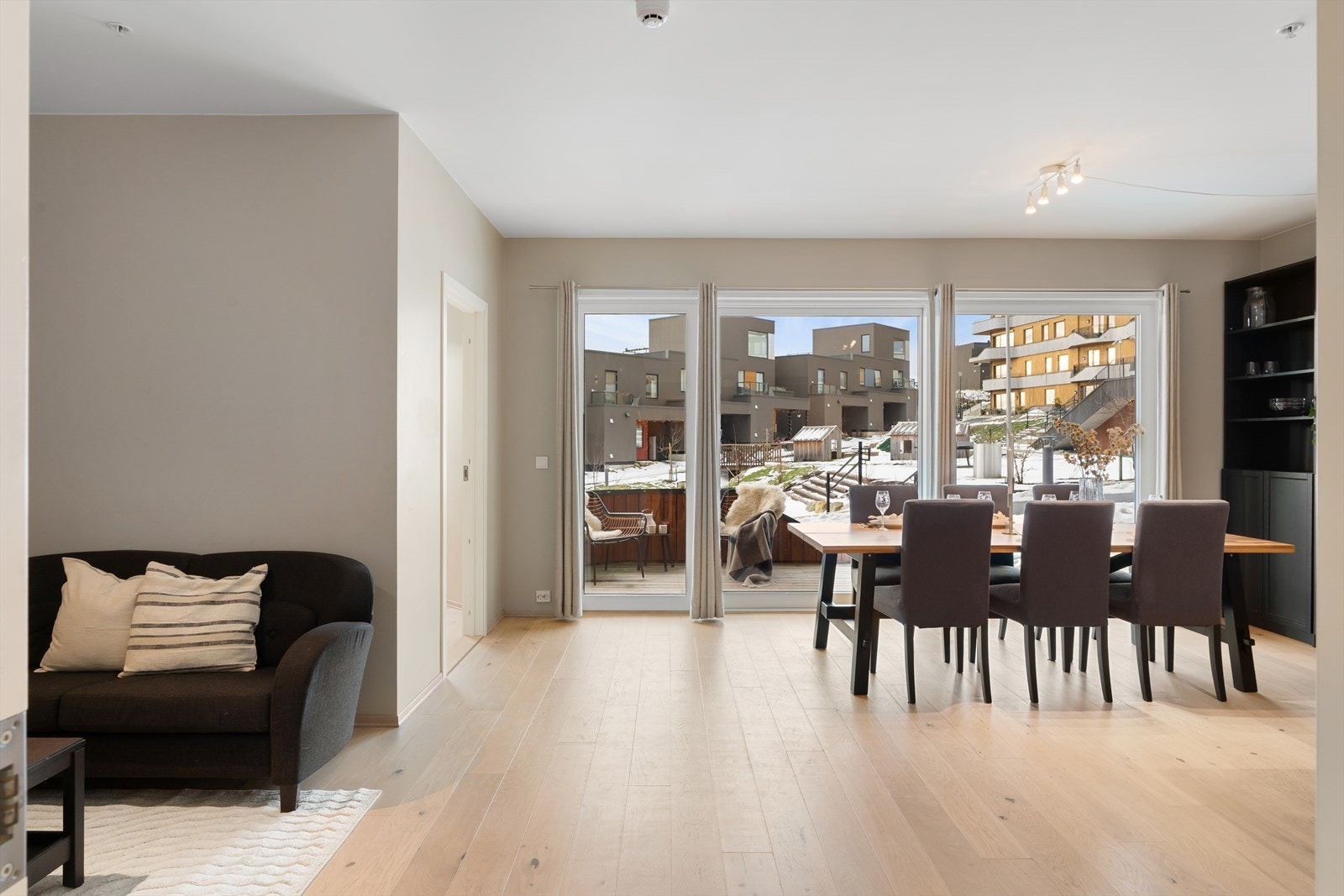 Stuen preges av store vindusflater som slipper inn rikelig med naturlig dagslys og skaper en lys og innbydende atmosfære Galleribilde