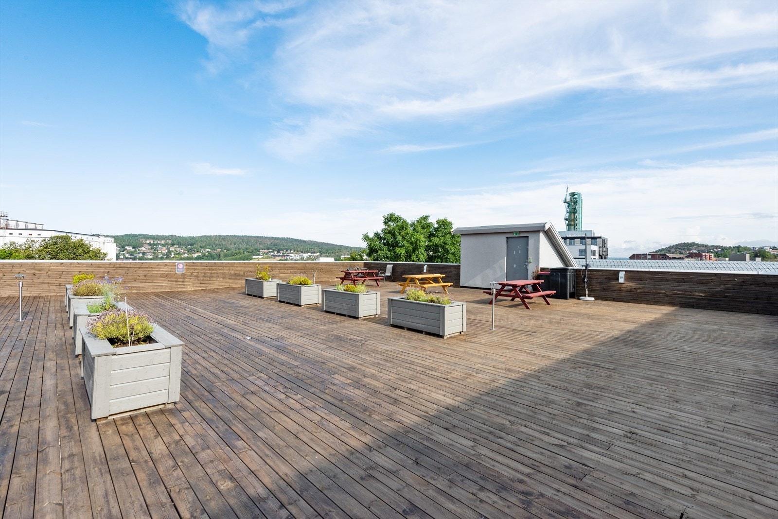 Leiligheten har i tillegg tilgang til felles takterrasse. Denne er romslig og tilrettelagt med sittegrupper og beplantning, og byr på gode solforhold og flott utsikt - et attraktivt felles uteareal for beboerne. Galleribilde