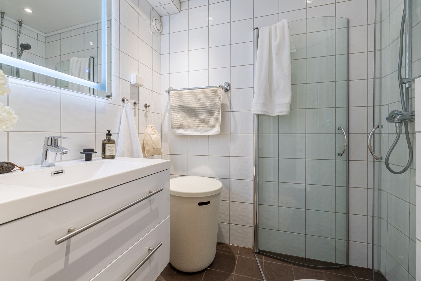 Stilrent baderom med varmekabler i gulv. Innfellabare dusjdører og speil med integrert belysning. Galleribilde