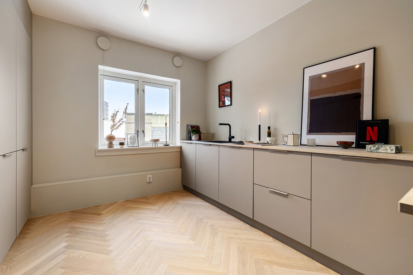 Det er satt inn takhøye skap langs hele rekken til venstre - ideelt for oppbevaring. Kun underskap i åpen løsninng som skaper god flyt mellom de sosiale sonene. Galleribilde