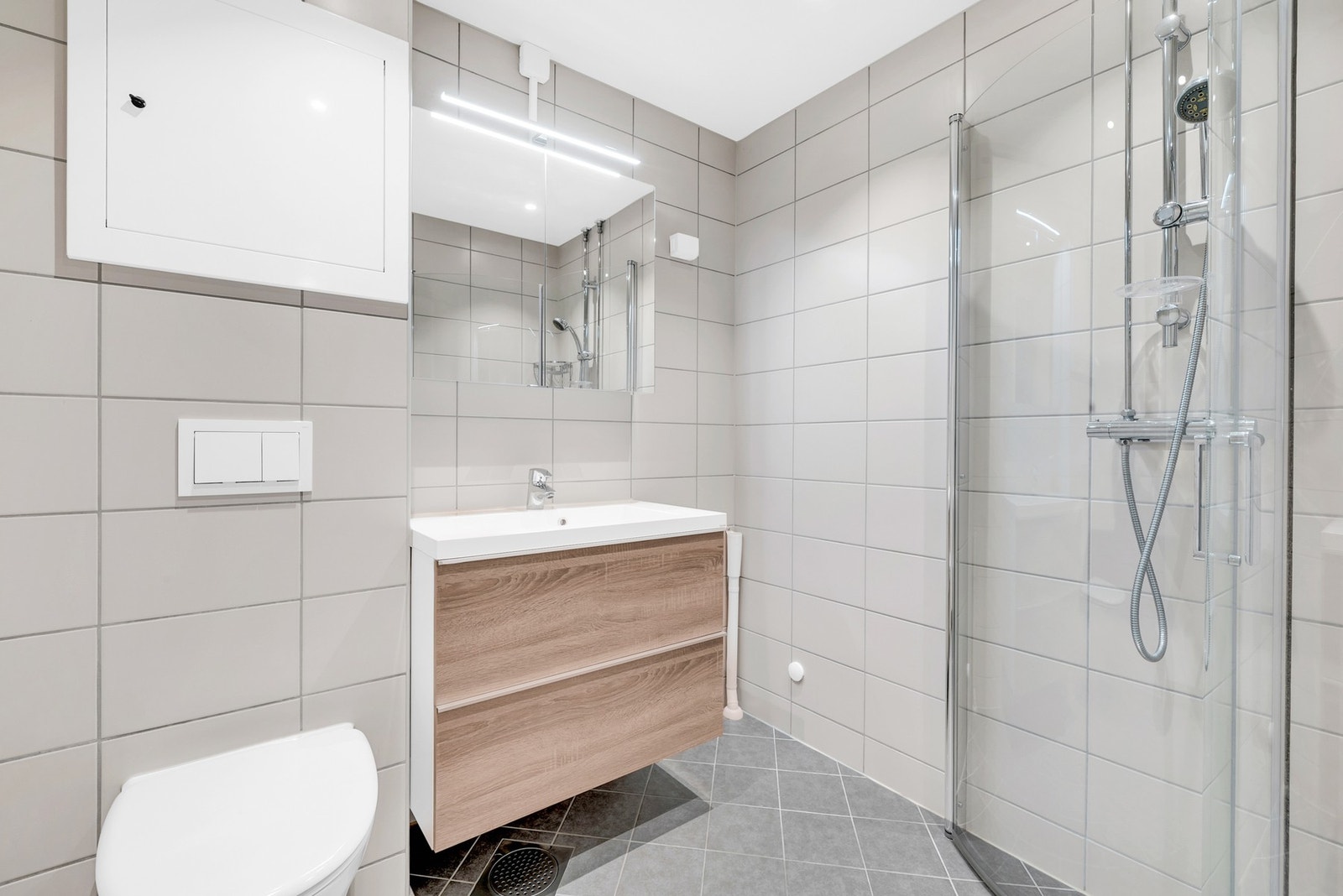 Baderommet ble pusset opp i regi av borettslaget rundt 2019 og fremstår som et moderne og funksjonelt rom med varmekabler og opplegg for vaskemaskin. Galleribilde