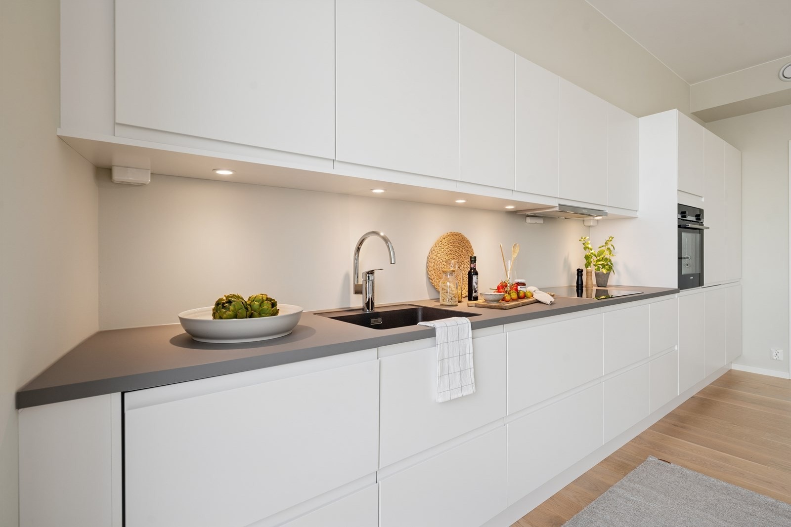 Kjøkkenet er utstyrt med integrerte hvitevarer som medfølger; komfyr, platetopp, ventilator, oppvaskmaskin og kjøl/frys. Galleribilde