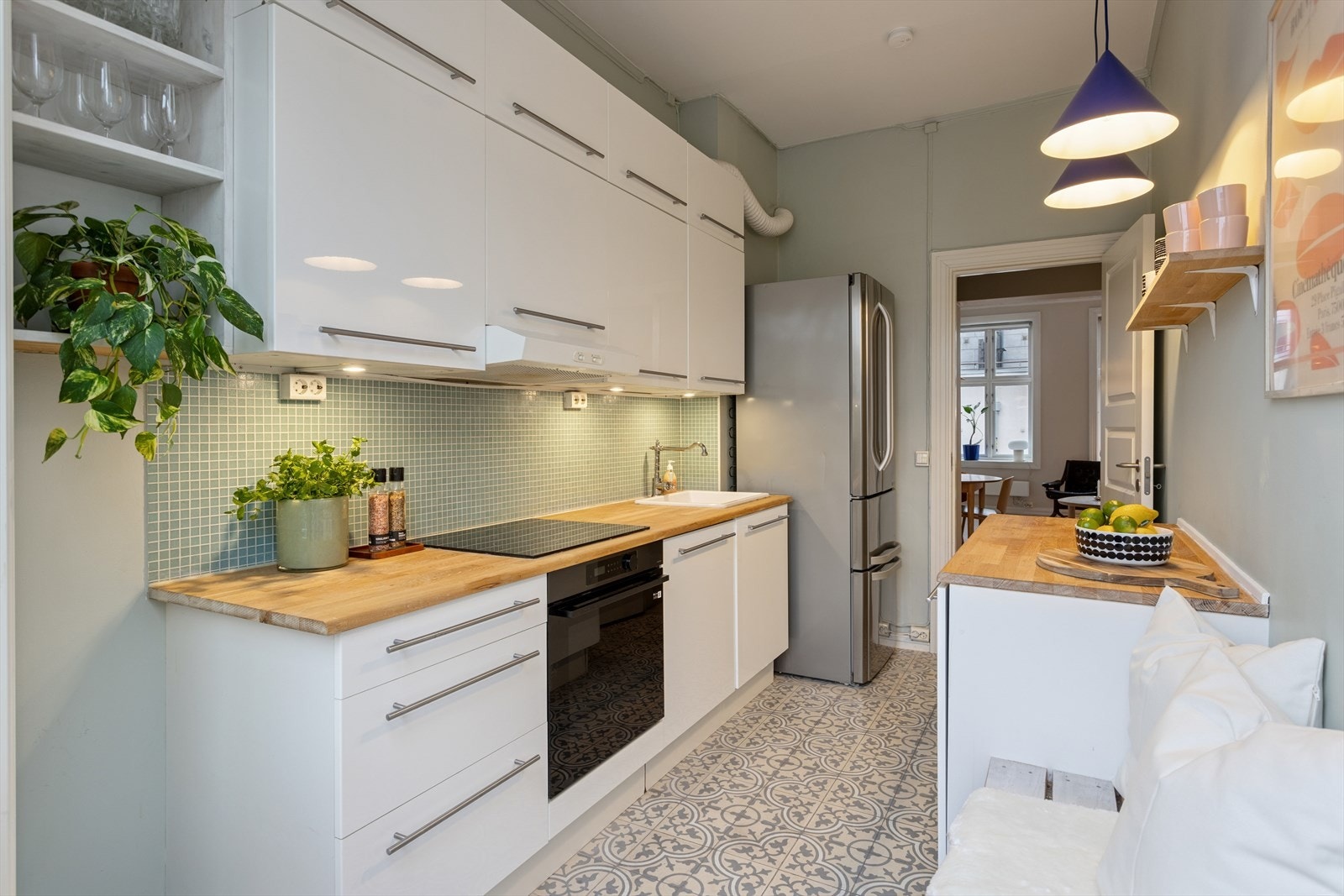 Benkeplaten i heltre eik gir en varm kontrast, og er utstyrt med nedfelt platetopp. Kjøkkenvasken i keramikk med ettgreps blandebatteri understreker den klassiske stilen. Galleribilde