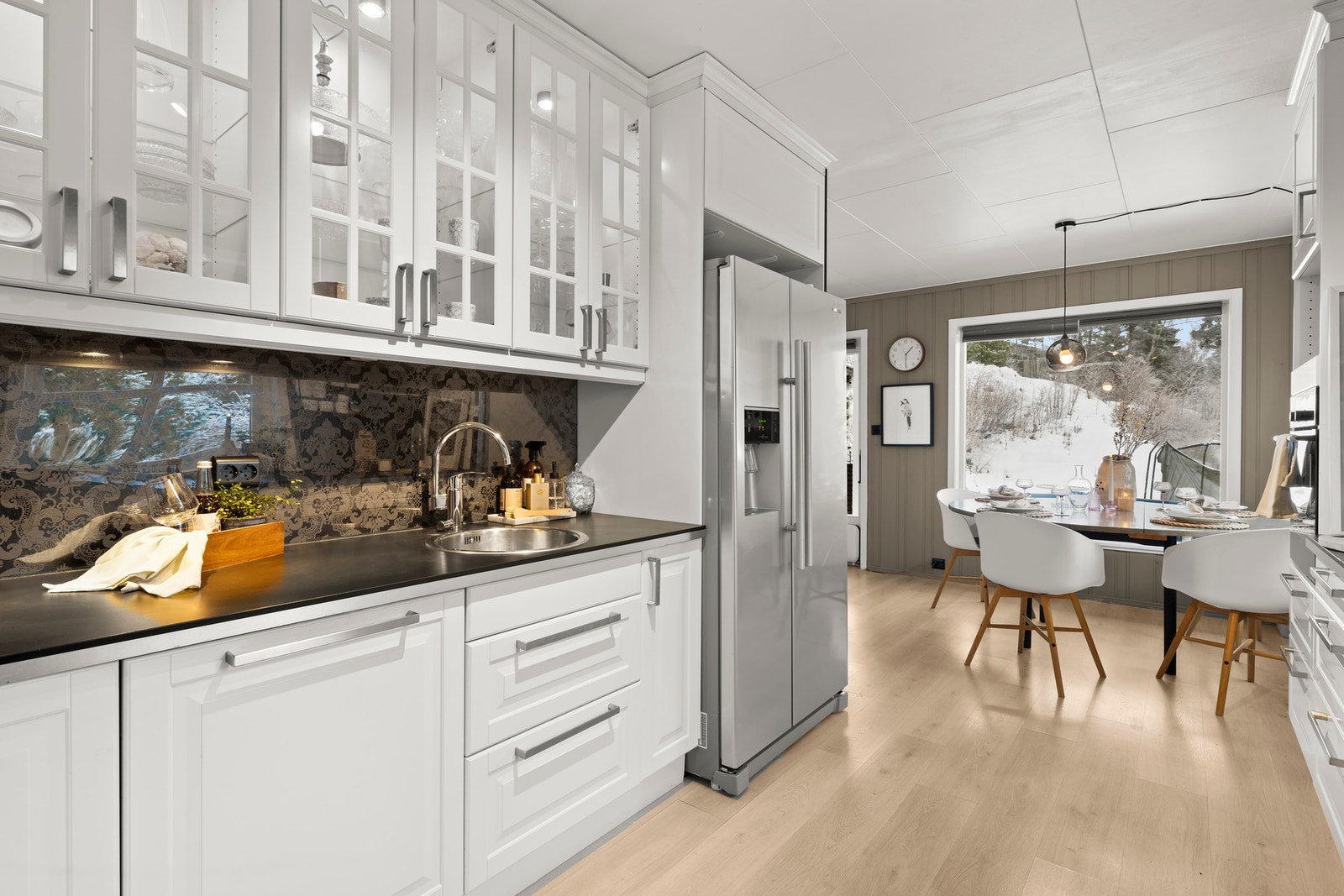 Kjøkkenet fremstår som et lyst og funksjonelt arbeidsrom, innredet med profilerte fronter og gode skap- og benkeløsninger. Galleribilde