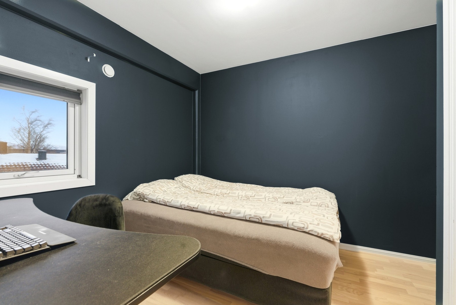 Romslig soverom malt i mørk blåtone og parkettgulv. Galleribilde