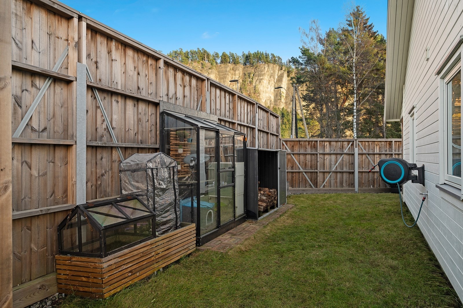 Del av hagen med levegg til veien. Galleribilde