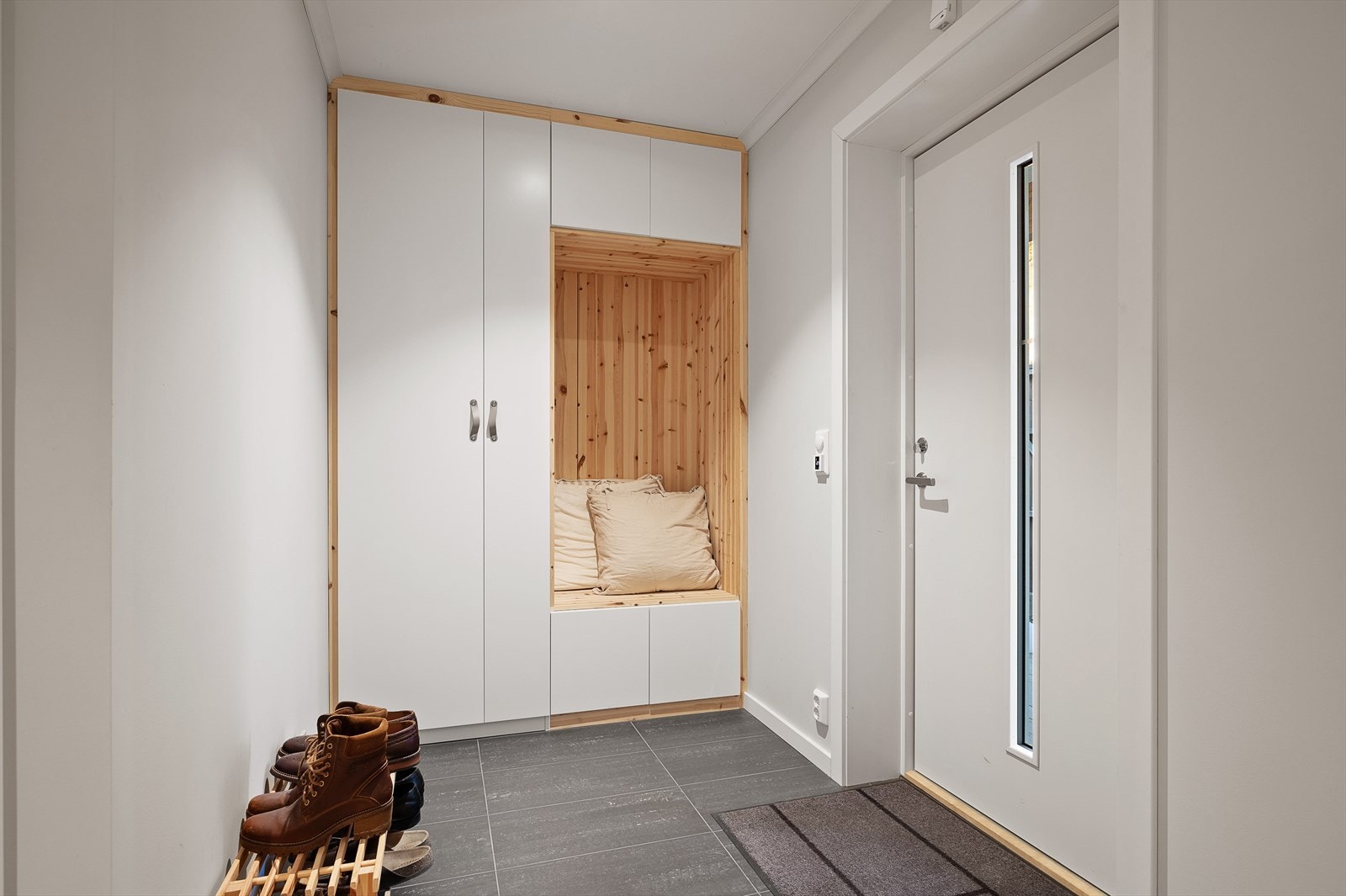 Velkommen inn! Lys og lekker entrè med plassbygget garderobe med hyggelig sittebenk Galleribilde