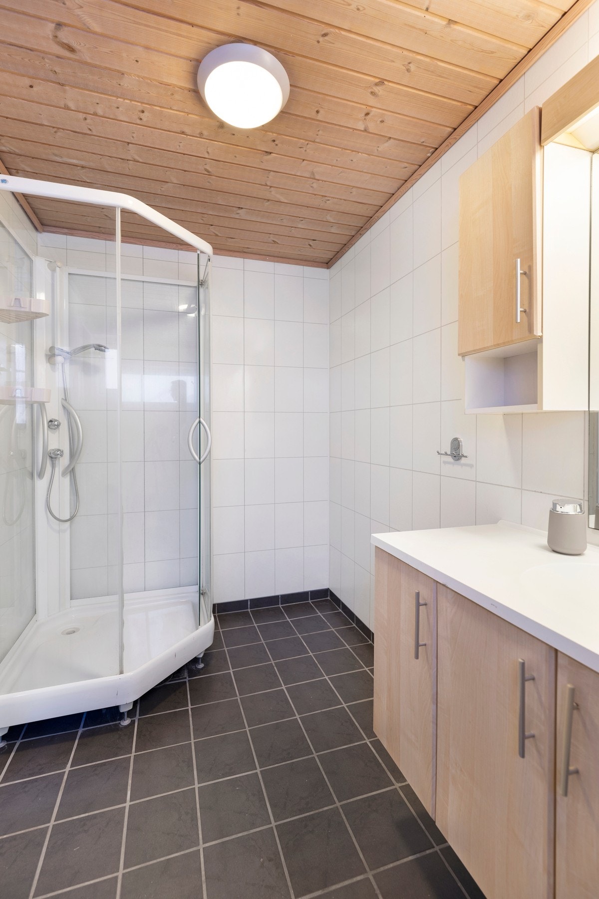 Badet inneholder videre dusjkabinett, toalett og baderomsinnredning. Galleribilde