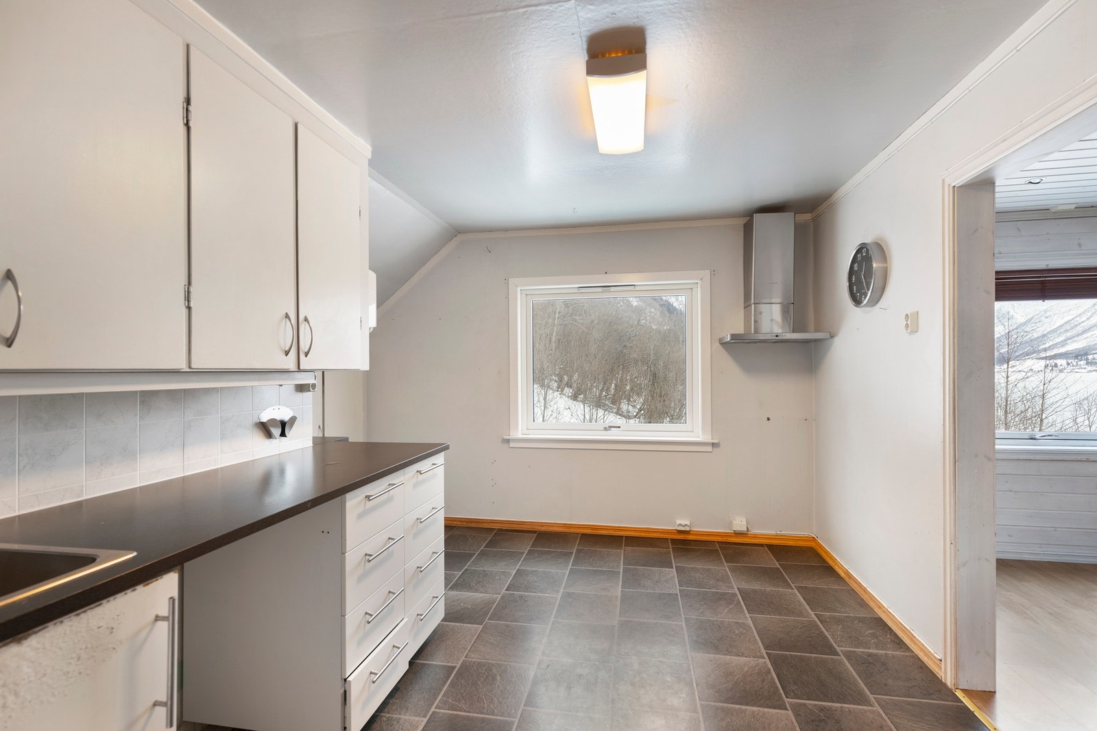 Kjøkkenet på loftet har en enkel innredning i hvite, slette fronter. Galleribilde