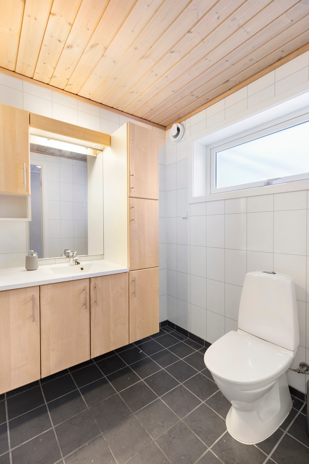 Badet har flislagt gulv og våtromsplater på vegger. Galleribilde