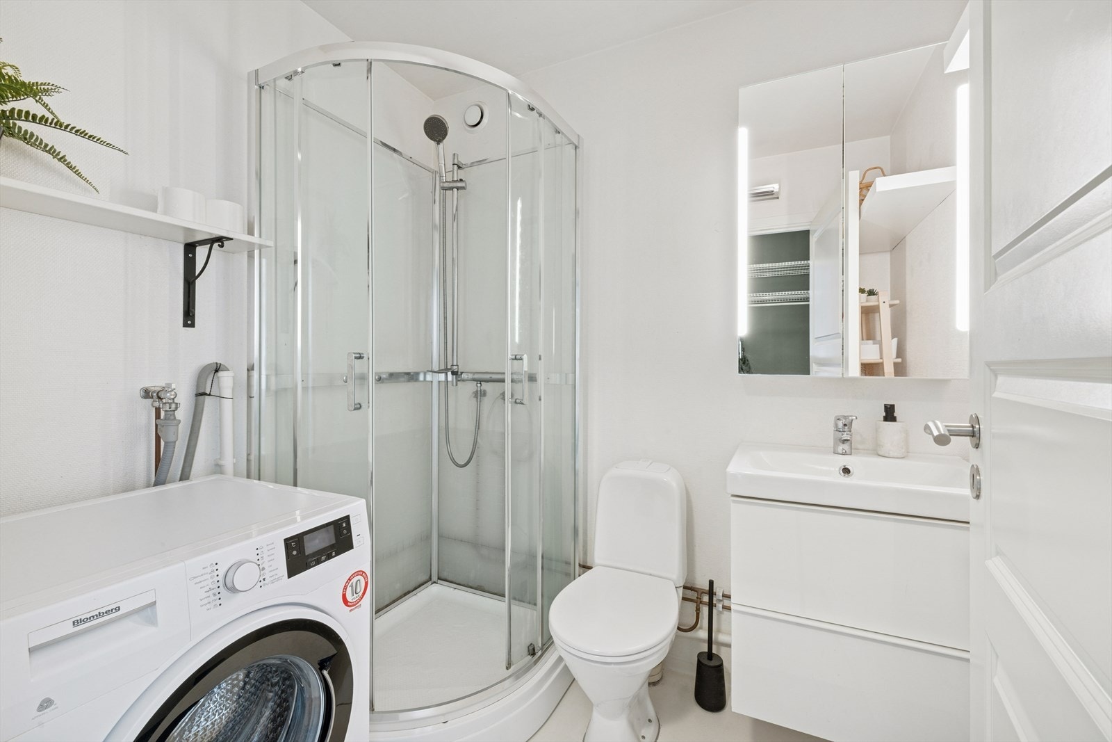 Baderom av god størrelse med opplegg for vaskemaskin. Galleribilde