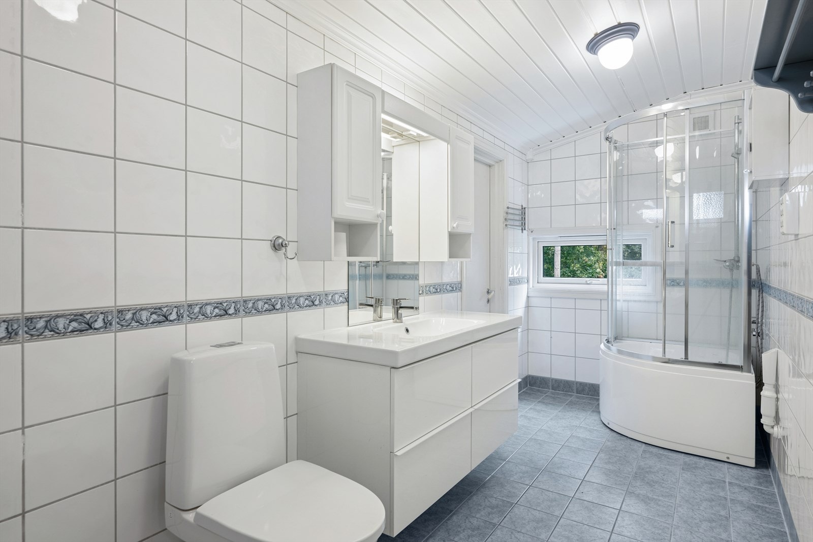 Rommet er utstyrt med servantinnredning, wc, dusjkabinett (nytt 2024) og opplegg for vaskemaskin. Galleribilde