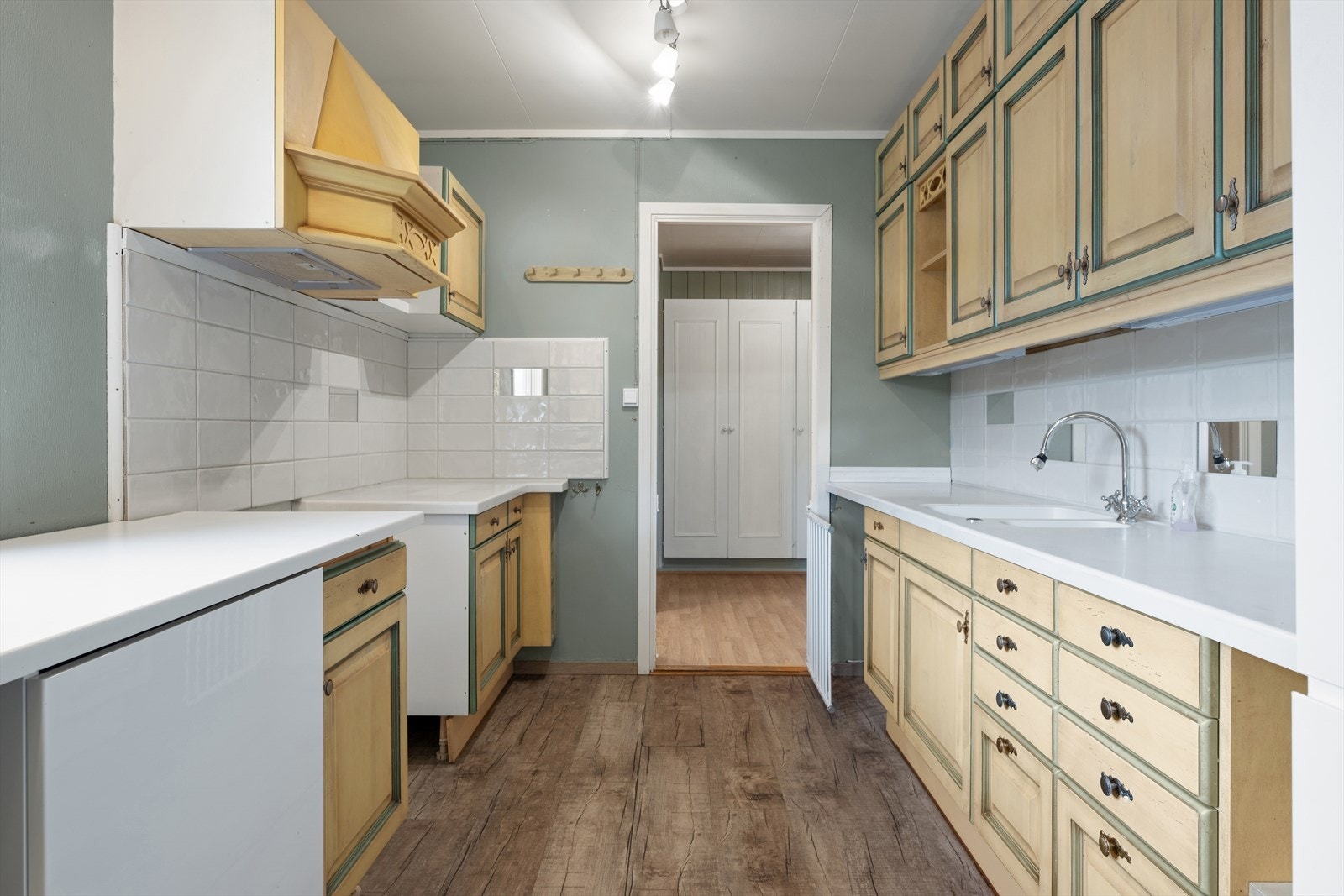 Praktisk og hyggelig kjøkken med god skapplass, hvit komposittbenk med dobbel vask og ventilator med avtrekk. Galleribilde