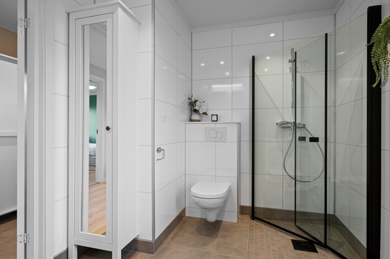 Her er det flislagt gulv med elektriske varmekabler, vegghengt toalett og dusjhjørne. Galleribilde