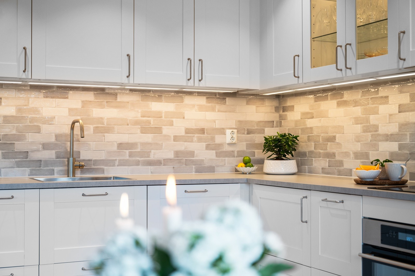 Flislagt veggfelt og god belysning under overskapene gir en funksjonell arbeidsflate. Galleribilde