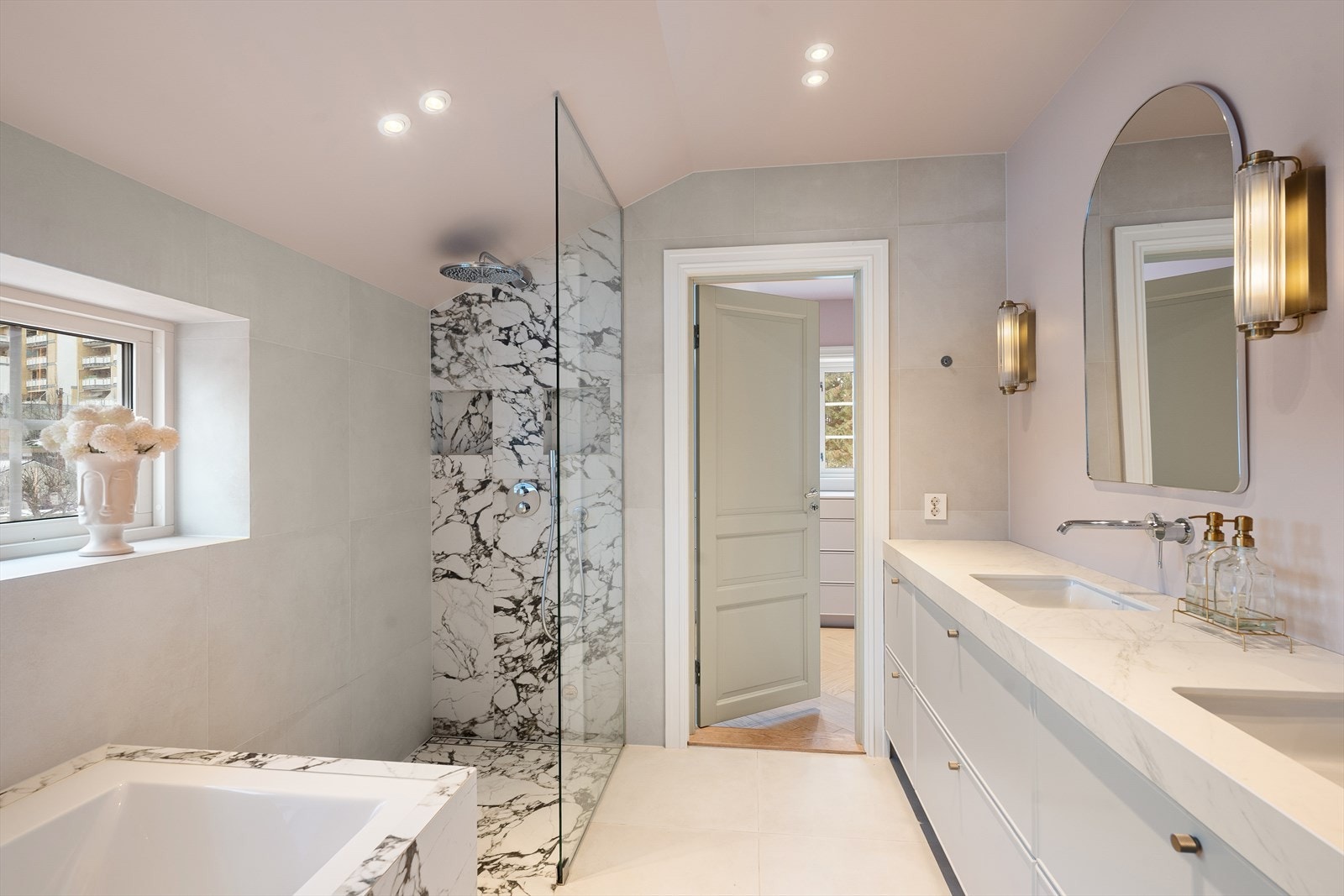 Masterbadet ligger i tilknytning til garderoberom fra hovedsoverom i 2. etasje. Badet fremstår moderne og påkostet, med gjennomgående 60 × 60 cm fliser i to ulike flistyper på både gulv og vegger. Gulvet har varmekabler som gir god komfort. Galleribilde