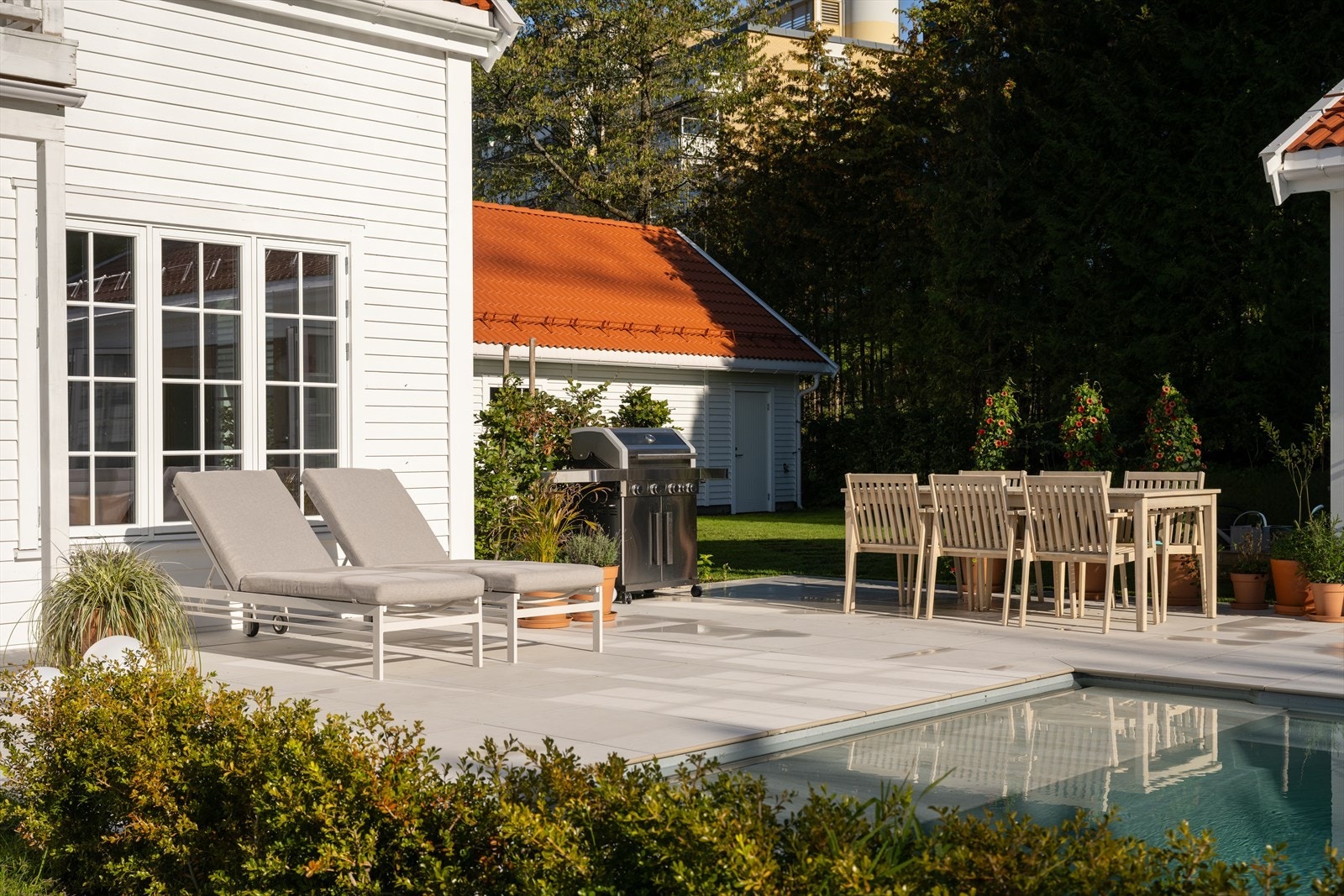 Her har man god plass til solsenger, grill, spisegruppe m.m. Det tekniske anlegget til bassenget er diskret plassert i bakken ved bassengets avslutning. På kortveggen av bassenghuset er det montert praktisk utedusj. Galleribilde