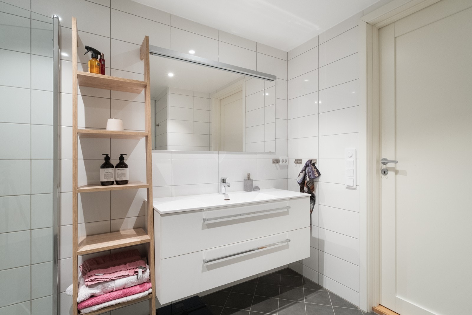 Baderomsinnredning med glatte, hvite fronter og heldekkende servant. Galleribilde