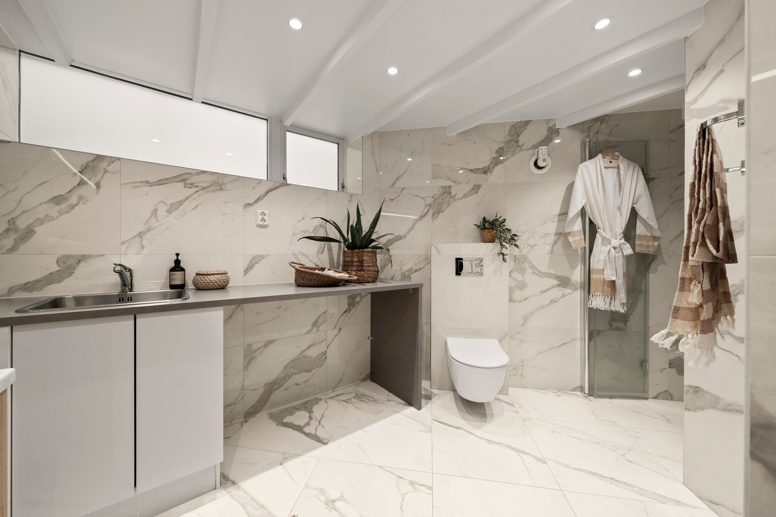 Dobbel servant, vegghengt toalett, romslig dusj og elektriske varmekabler gjør hverdagen både praktisk og komfortabel. Galleribilde