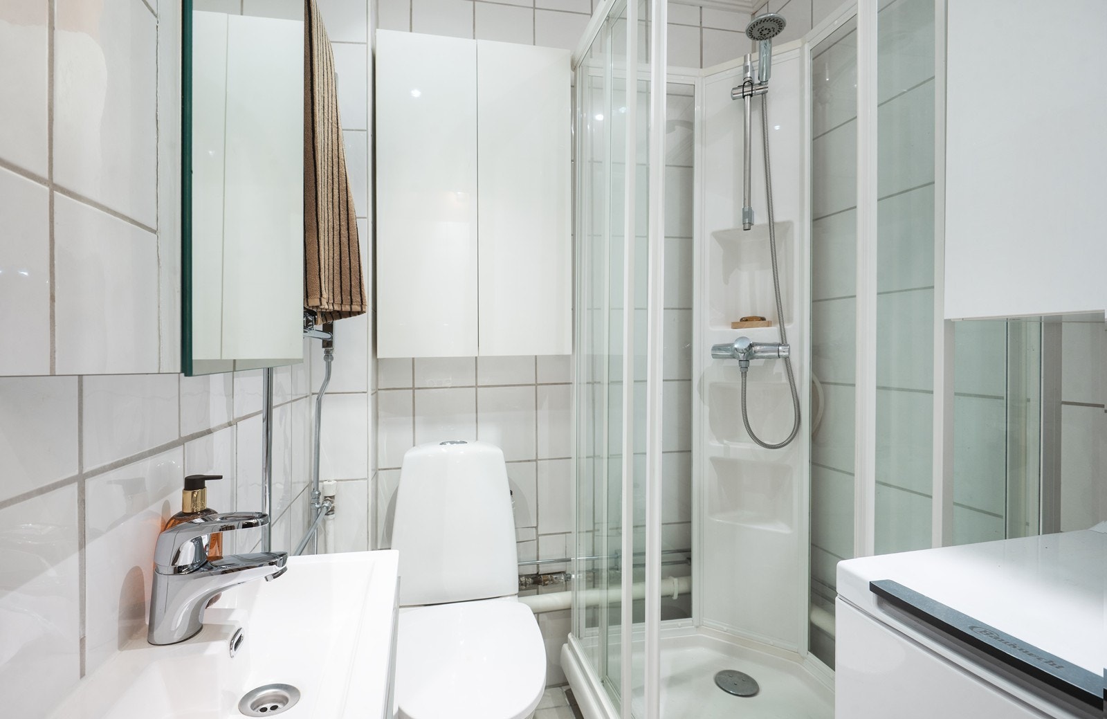 Bad med dusjkabinett, gulvmontert wc, servant og opplegg for vaskemaskin (medfølger) Galleribilde