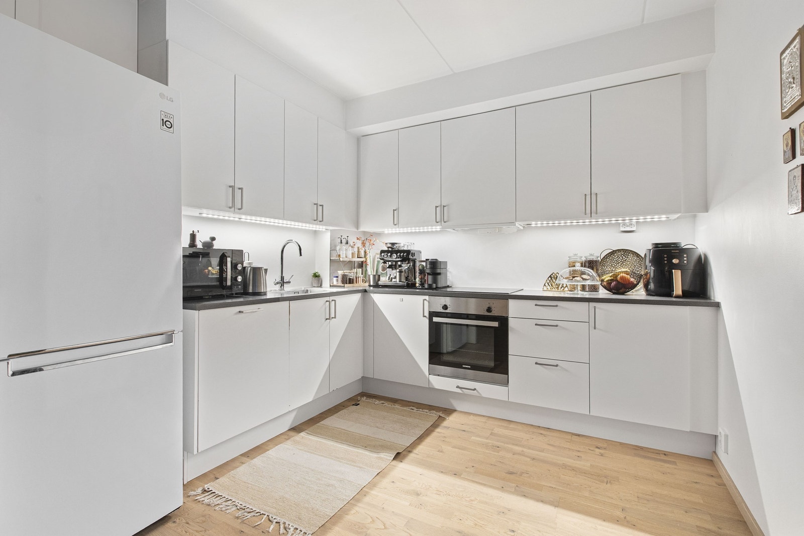 Åpen kjøkkenløsning med integrert stekeovn, platetopp og oppvaskmaskin Galleribilde