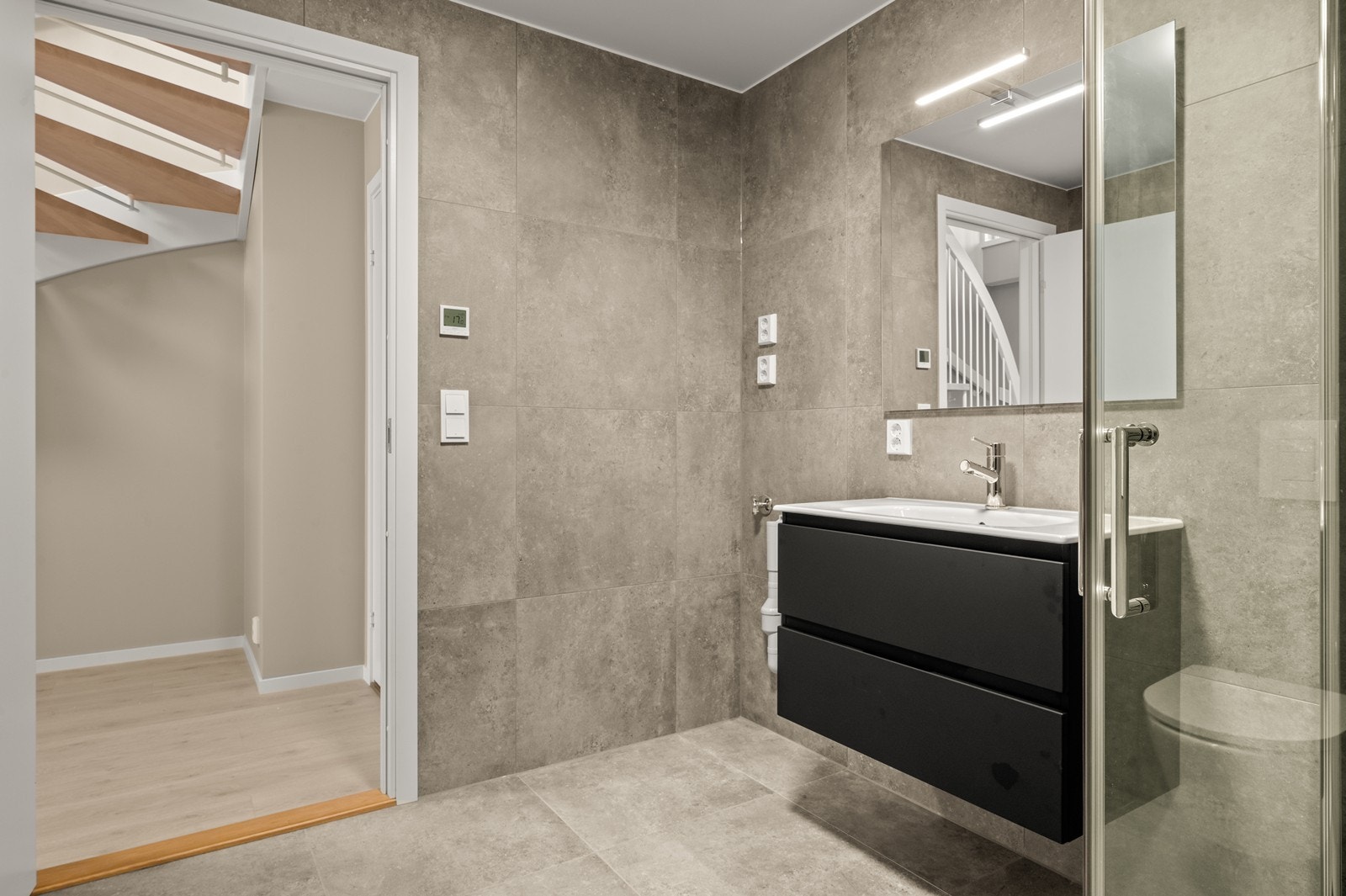 6 Rommet er utstyrt med vegghengt toalett og et dusjhjørne med innfellbare glassdører. Galleribilde