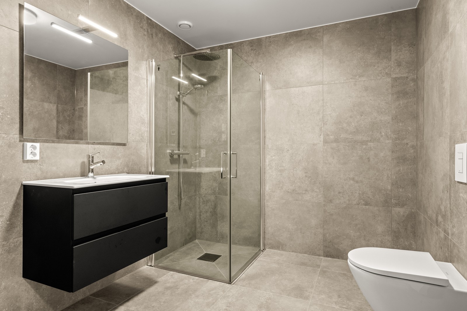 Meget delikat og innbydende bad i underetasjen, med fliser på gulv og vegger. Galleribilde