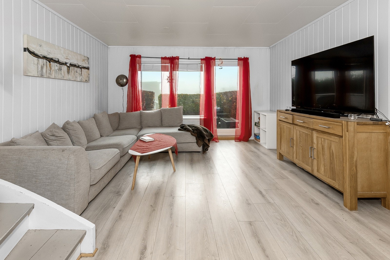 Lys og innbydende stue - verandadør ut til platting og liten hage. Galleribilde