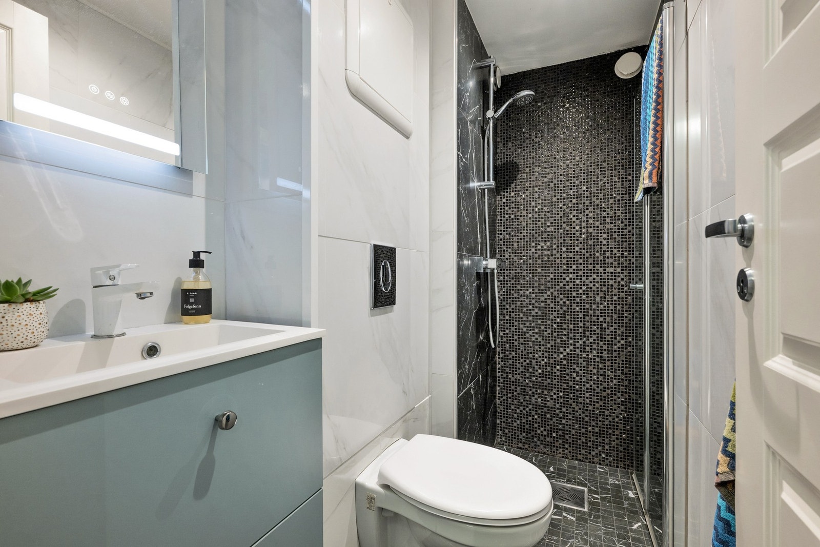 Adkomst fra entré til delikat bad fra 2019, senere oppgradert med flis-på-flis og ny baderomsinnredning av dagens eiere. Galleribilde