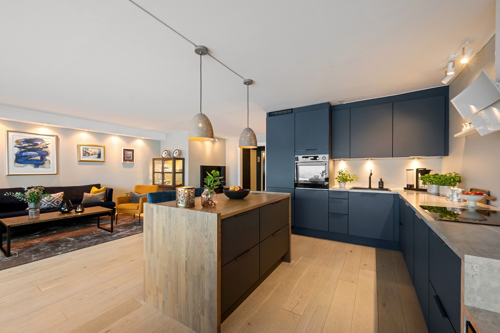 Romslig og tiltalende stue med åpen kjøkkenløsning og sosial kjøkkenøy. Galleribilde