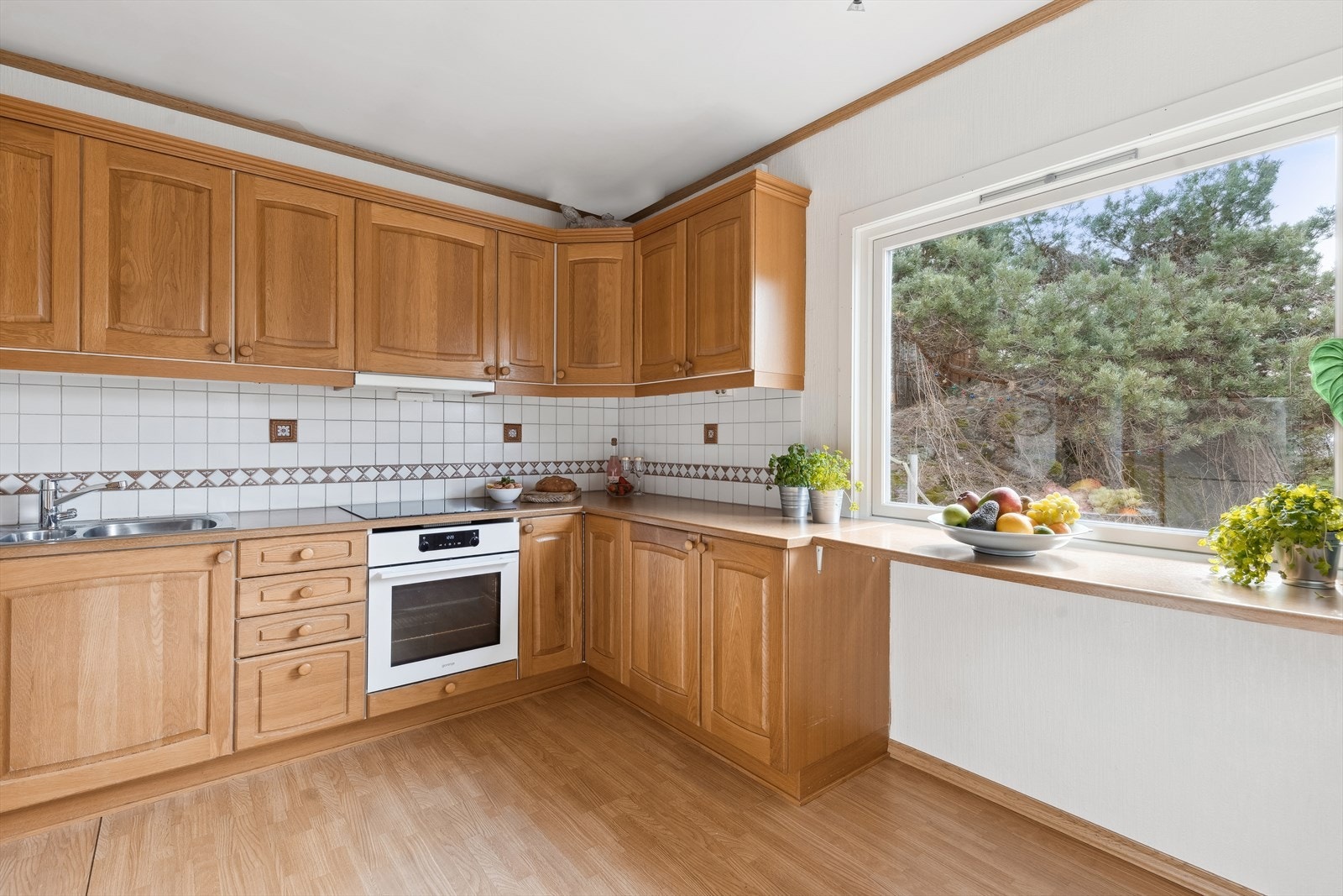 Kjøkkeninnredningen har profilerte fronter og en laminat benkeplate, og består av både over- og underskap. Galleribilde