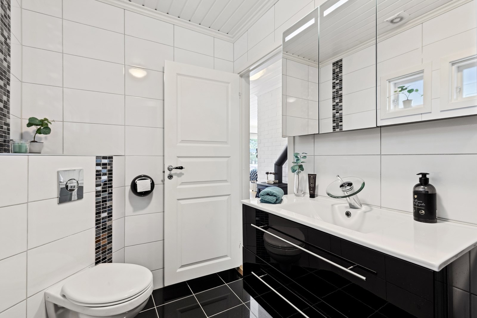 Innredningen består av speilskap med belysning, servant med skuffeseksjon, veggmontert toalett, oppbevaringsskap og dusjkabinett. Galleribilde