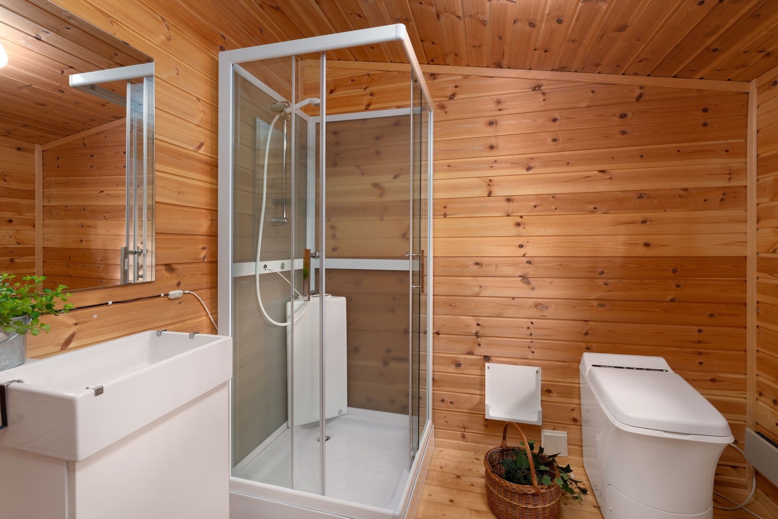 Hygienerom med servant, dusjkabinett med pumpekanne og forbrenningstoalett. Galleribilde