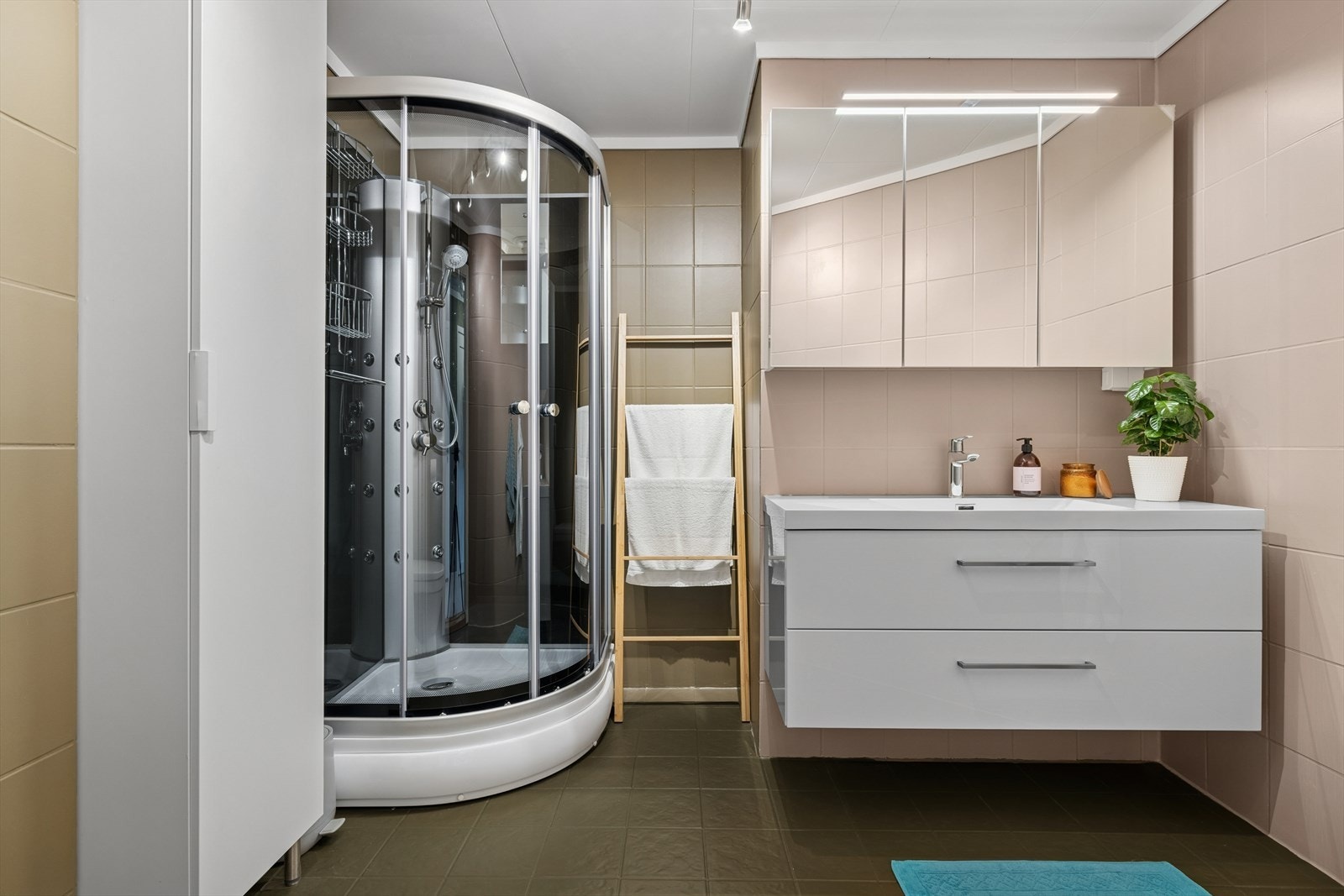 Baderom med flis på gulv og vegger, og takess plater i himling. Galleribilde