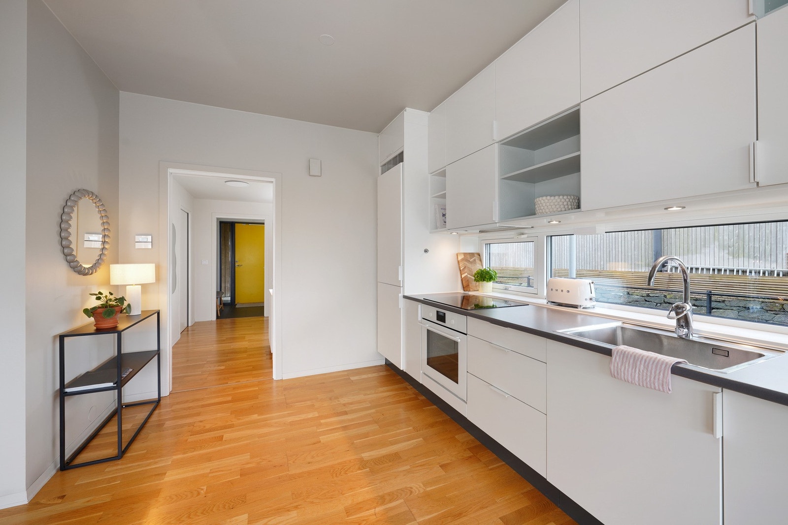 Kjøkkenet er innredet med skapplass helt opp til taket Galleribilde