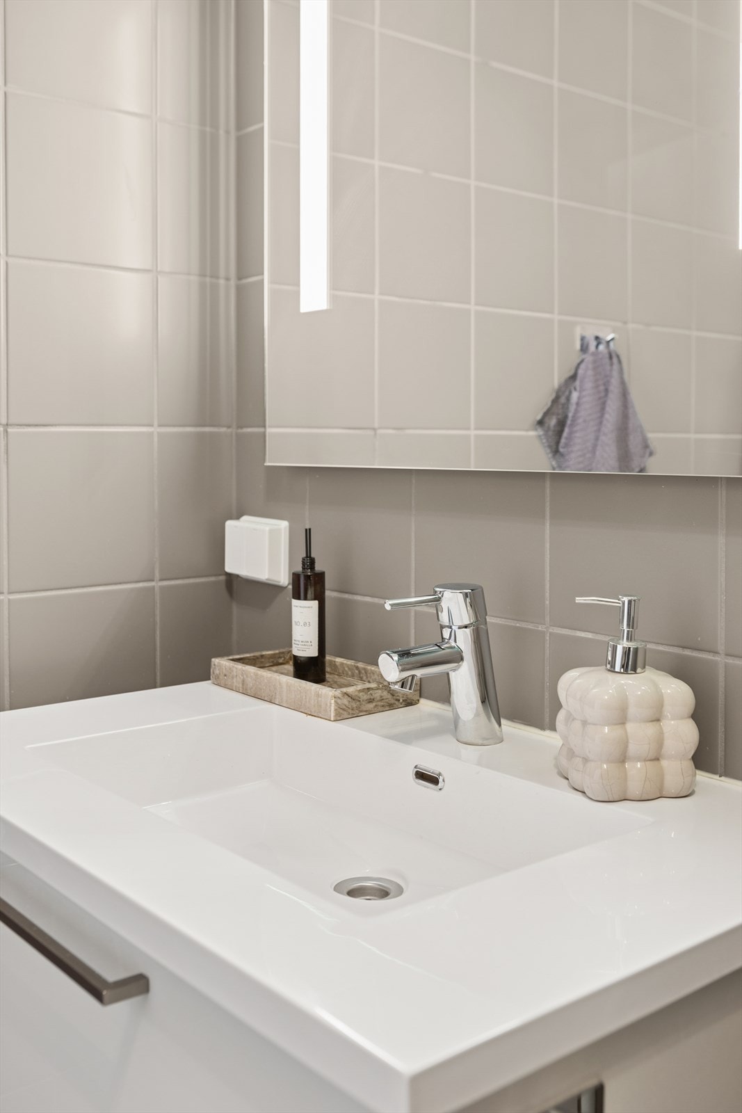 Speil og servantskap kompletterer badet med praktisk oppbevaring og stilrent design (kilde: tilstandsrapport). Galleribilde