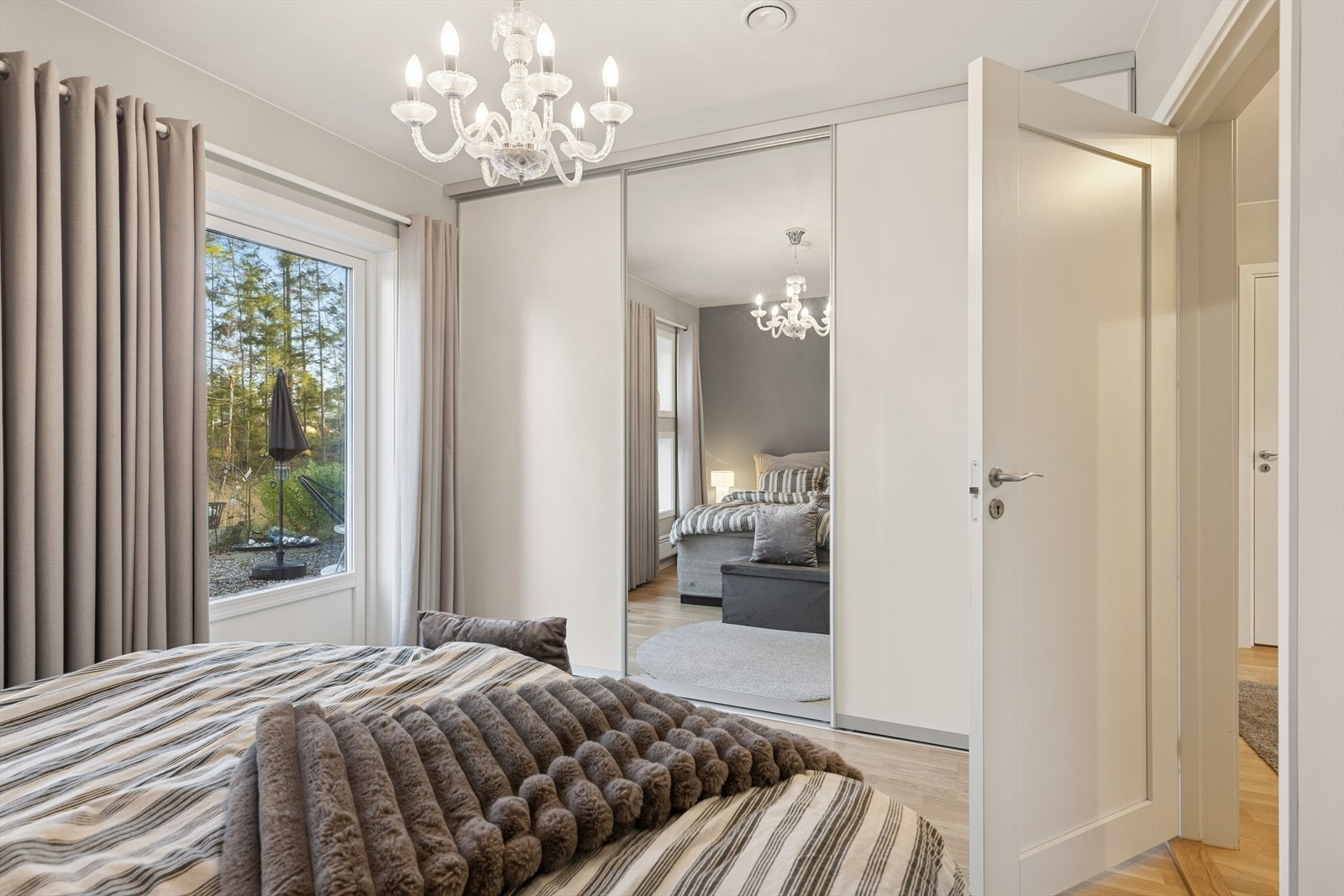 Skyvedørsgarderobe med speil gir rommet en praktisk oppbevaringsløsning. Galleribilde