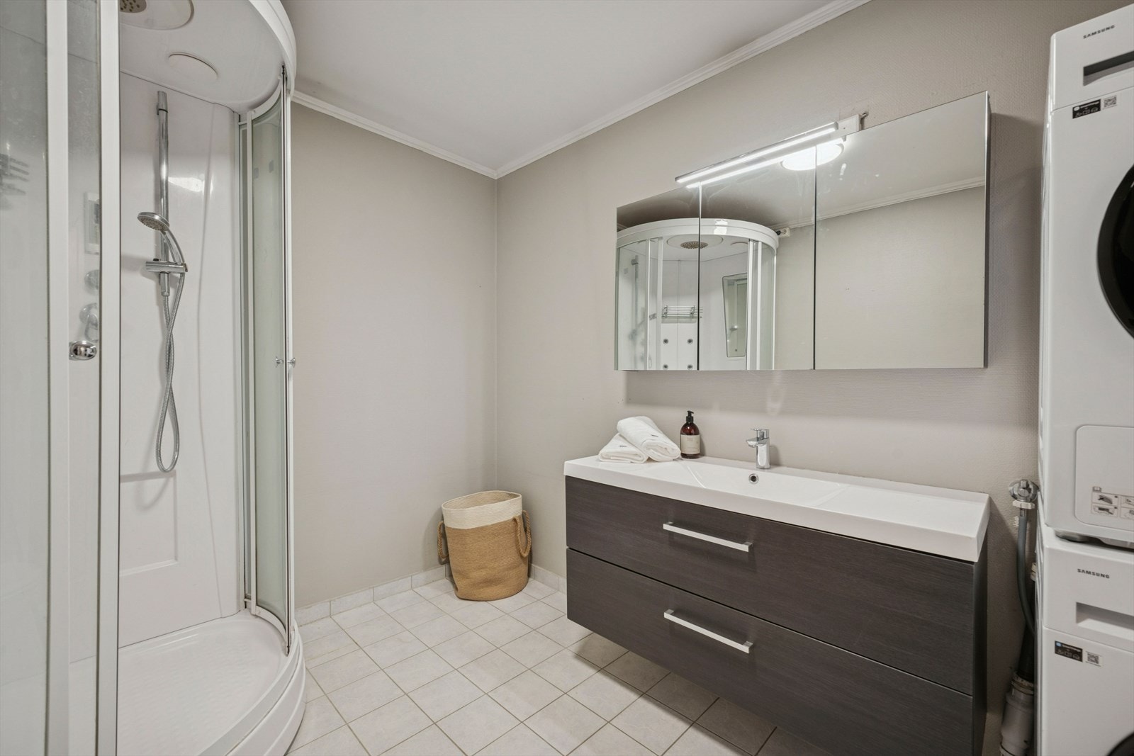 Badet har tidløse fliser på gulvet med varmekabler og tapet på veggene. Galleribilde