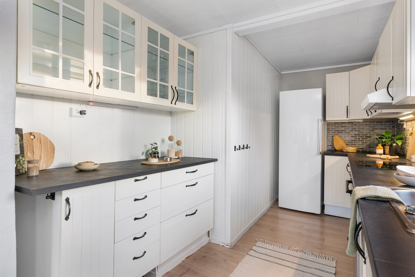 Kjøkkenet har innredning med profilerte fronter og laminert benkeplate. Det ble montert ekstra skap og benkeplass i 2025. Galleribilde