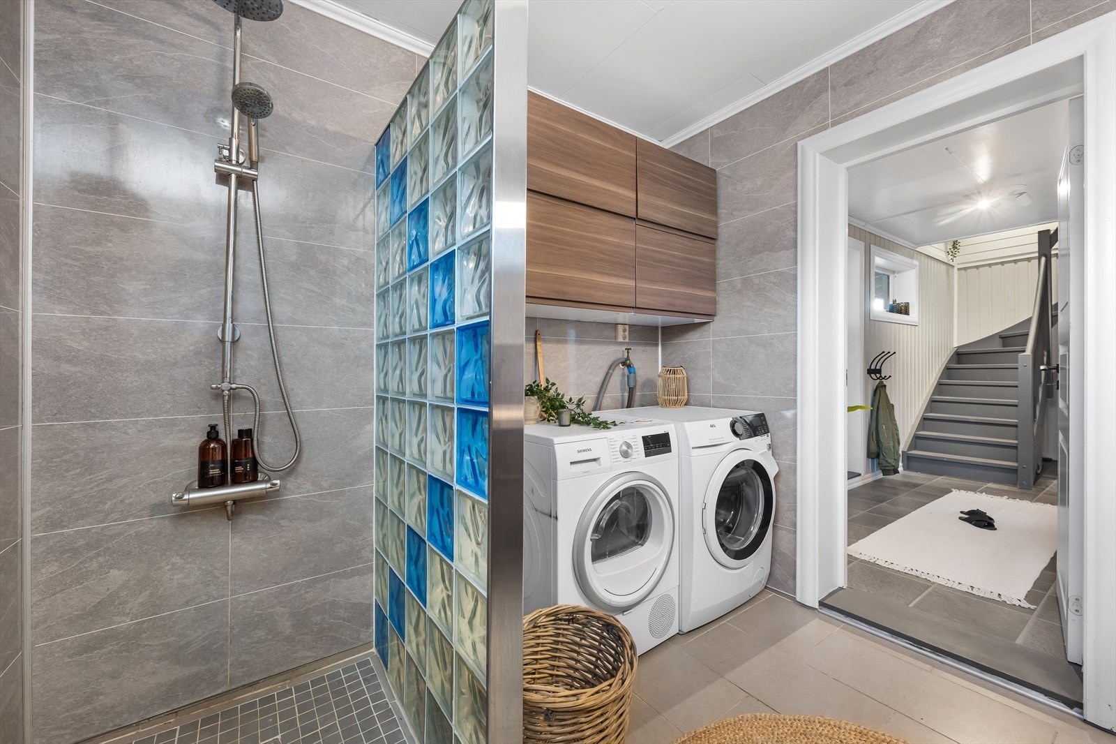 Badet har et moderne preg med fliser i gulv og baderomsplater på vegg. Galleribilde